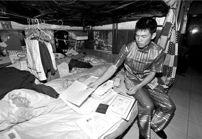 杨绍平在床上展示他得到的资格认证证书。本报记者陶冉摄